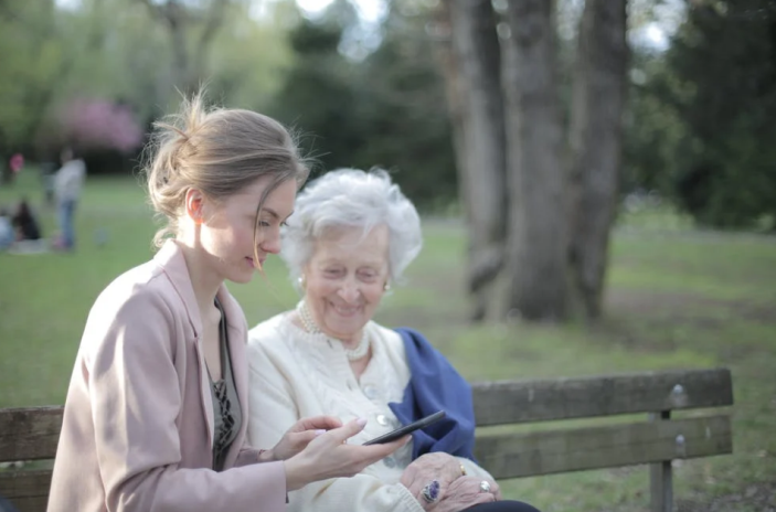 Young woman teaching elder partent about personal finance