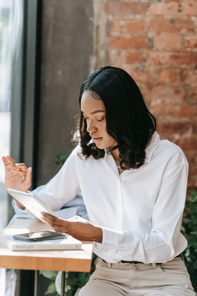 Woman Wearing a Long Sleeve Polo Using a Tablet