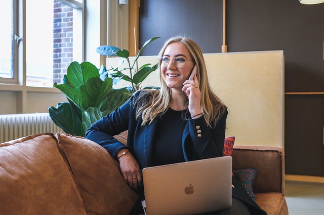 Woman in Blue Long Sleeve Shirt Using Macbook