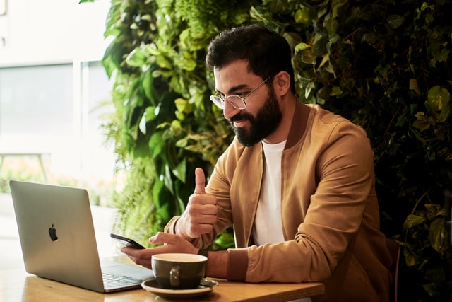 Man working on laptop and drinking coffee