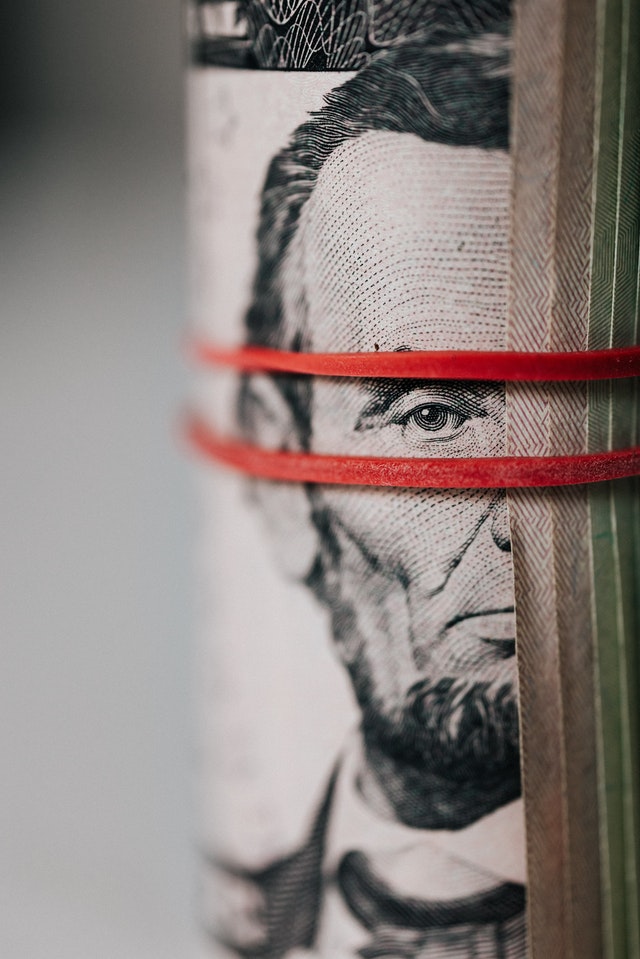 Roll of American dollar banknotes tightened with band