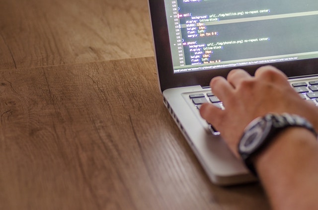 A person writing code on a laptop