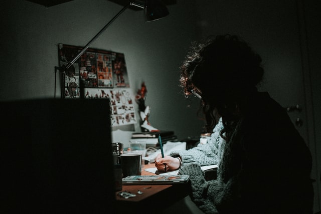 A woman writing on a table at night