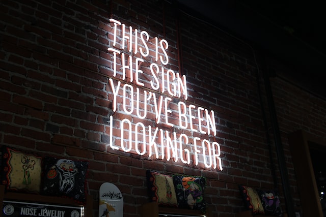 White neon sign on a brick wall