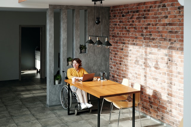 Women sitting in a wheelchair, while working at the office