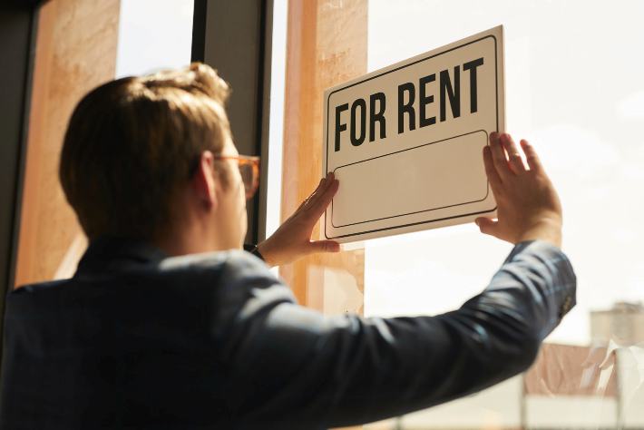 Landlord putting a For sale sign