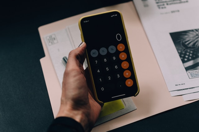 women's hand holding a calculator