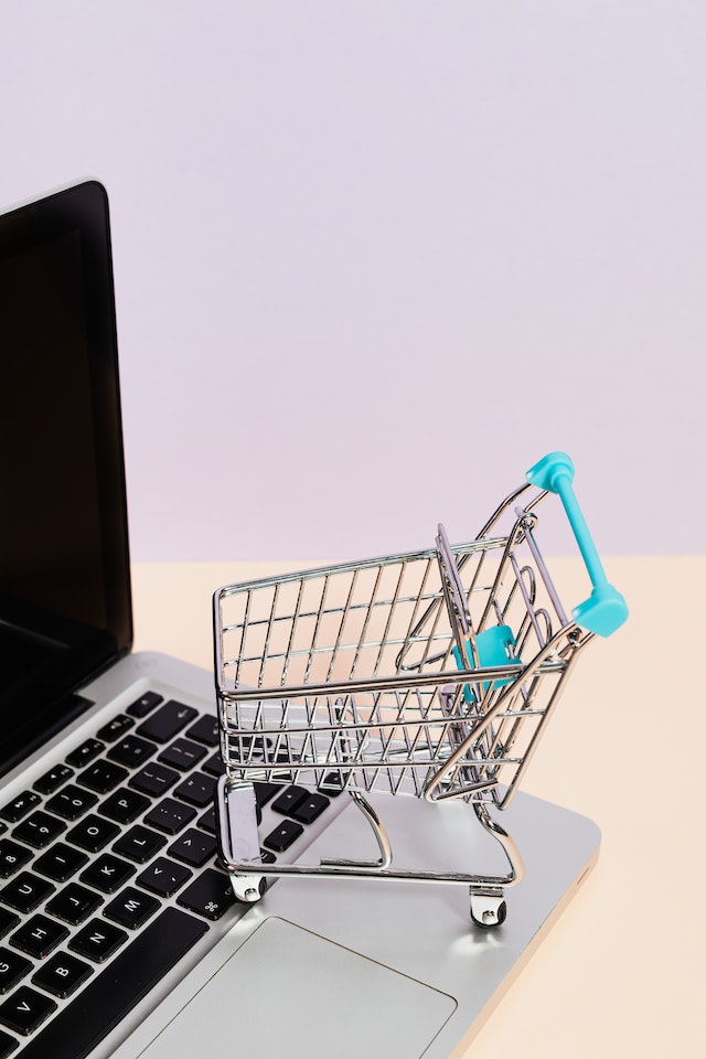 Small shopping cart and open laptop