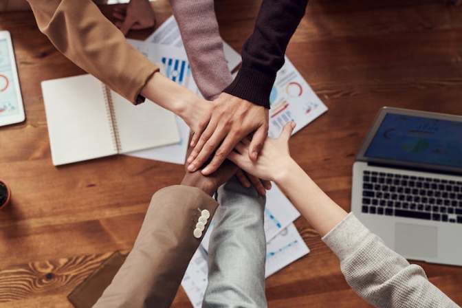 Hands on top of each other in a team building gesture