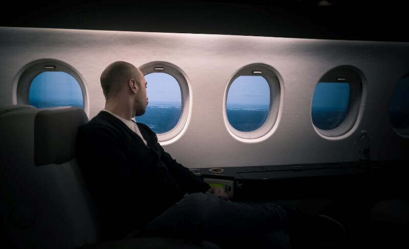 Man in an airplane looking out of the window.